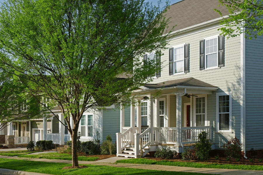 quiet street in a suburban neighborhood with beautiful homes, trees, and sidewalks